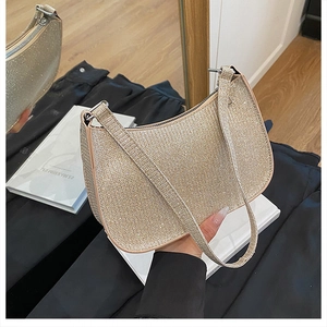 Gros plan d'un sac baguette pailleté beige avec fermeture éclair métallique et bandoulière