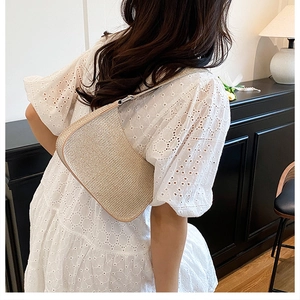 Gros plan sur la texture tissée métallisée dorée d'un petit sac baguette en croissant