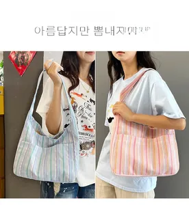 Vue détaillée de grands sacs cabas en toile rayée avec poches latérales en deux coloris
