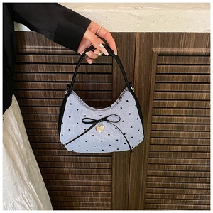Gros plan du sac en toile rayé avec motifs de cœurs et détail de nœud en ruban noir