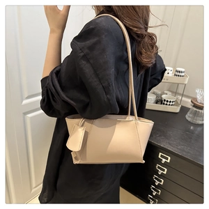 Chic beige trapeze shoulder bag in smooth leather texture styled with a black linen outfit