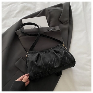 Detailed view of black pleated underarm bag texture on a gray suit jacket