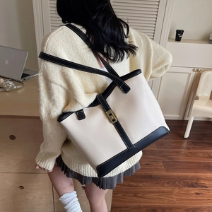 Grand sac cabas crème avec bordure noire et fermoir doré dans un bureau à domicile