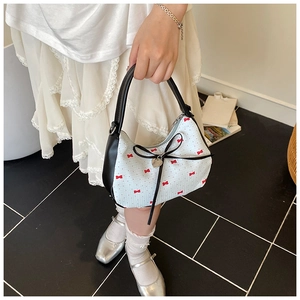 Détail du sac à bandoulière blanc avec pendentif cœur et nœud en ruban floral