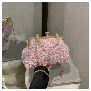 Detailed macro view of pink 3D flower petals and white pearls on the evening clutch bag