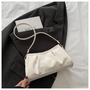 Close-up of cream pleated cloud bag featuring delicate marble texture and golden buckle