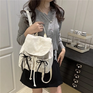 Sac à dos blanc plissé en nylon avec broderie Nika et nœud noir sur mannequin