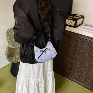 Sac à bandoulière lilas avec motifs cœurs et nœud porté par un mannequin féminin