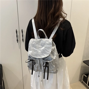 Sac à dos argenté métallisé pour femme avec nœuds noirs et fermeture à cordon coulissant