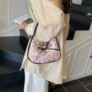 Sac sous le bras rose et noir avec motif de nœuds et pendentif en cœur