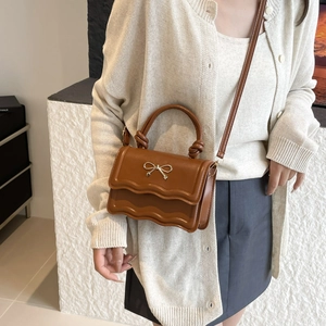 Sac à main vintage marron pour femme avec rabat ondulé et nœud doré élégant