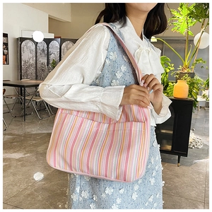 Détail d'un sac à bandoulière en nylon à rayures avec poche avant au style décontracté