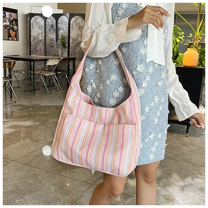 Détail du sac hobo en nylon à rayures colorées avec grande poche avant et intérieur spacieux