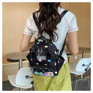 Detail eines schwarzen Mini-Rucksacks mit bunten Sternen und transparentem PVC-Frontfenster
