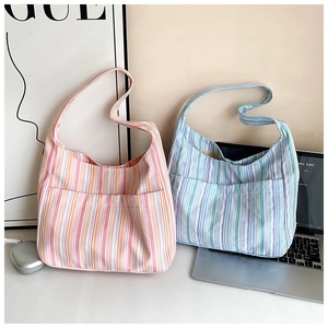 Vue détaillée de sacs cabas en toile rayée avec deux grandes poches frontales et anses
