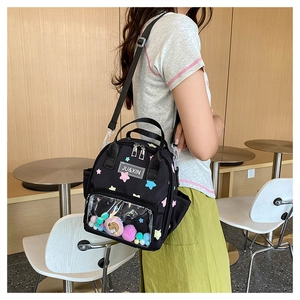 Detail des schwarzen Stern-Rucksacks mit transparentem Fenster und bunten Plüschkugeln