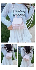 Detail of light pink mini drawstring backpack with pleated texture and magnetic flap closure
