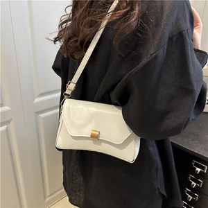 Borsa baguette bianca minimalista con fibbia in metallo dorato portata a spalla