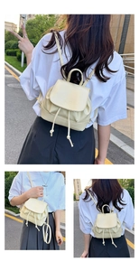 Detail of cream pleated backpack featuring mim logo embossing and drawstring closure
