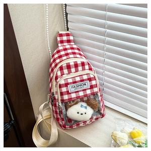 Detail of red and white plaid chest bag with transparent window and cute puppy doll inside