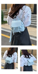 Detailed view of light blue mini backpack with drawstring and embossed logo detail