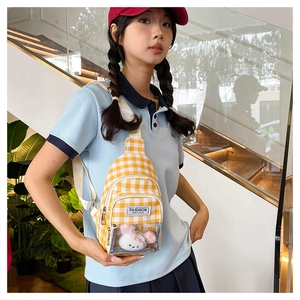 Detail of yellow checkered crossbody bag with cute bunny plush in clear front pocket