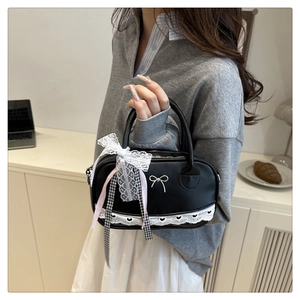 Close-up of black PU handbag featuring white lace bow and checkered ribbon details