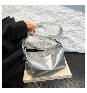 Detail of silver metallic shoulder bag with mirror finish and adjustable wide strap