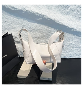 Glossy white faux leather shoulder bag featuring silver buckle and wide strap detail