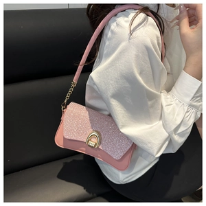 Detail of pink glitter shoulder bag with golden U-shaped lock and sequined flap design