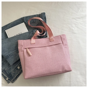 Pink woven texture tote bag detail showing large capacity and decorative rope zipper pull