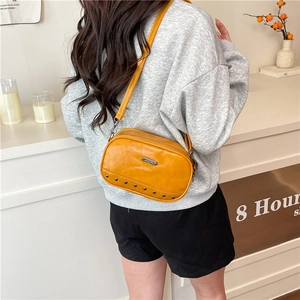 Ginger yellow crossbody square bag with metallic rivets and adjustable shoulder strap