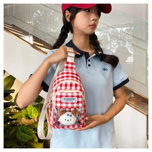 Detail of red checkered canvas crossbody bag with a cute plush dog in a clear window