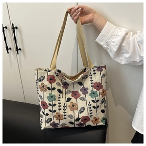Detail of floral canvas tote bag showing colorful jacquard pattern and wide strap