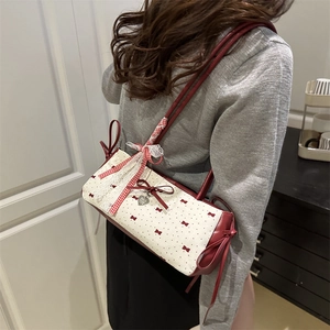 Sac cylindrique chic avec nœuds rouges et motif à pois porté par un mannequin