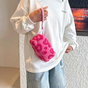 Pink plush cosmetics bag with 3D flocking heart patterns and matching wrist strap