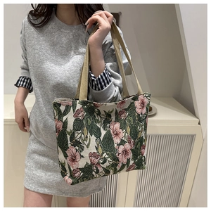 Detail of floral jacquard fabric and webbing strap on a large canvas tote bag