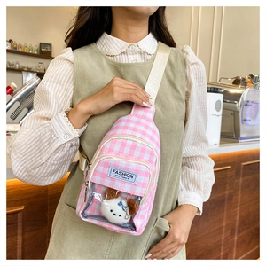 Close-up of pink checkered crossbody bag with transparent pocket and cute plush toy