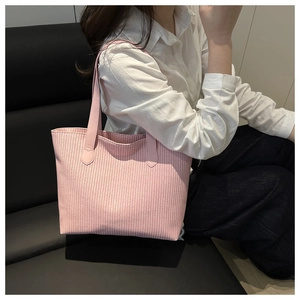 Detail view of pink woven tote bag showing fine vertical texture and leather strap