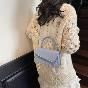 Light blue faux leather crossbody bag with quilted texture and gold lettering detail
