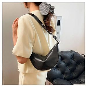 Side view of a black crescent shoulder bag featuring sleek leather and silver buckle