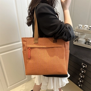 Orange woven tote bag with front zipper pocket and brown shoulder strap for casual use