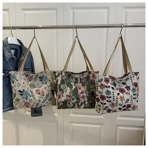 Detailed macro view of three ethnic style canvas tote bags with various floral patterns