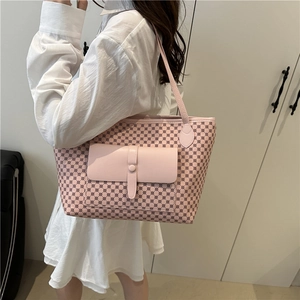 Pink tote bag with geometric print and front flap pocket shown on a model in a white dress