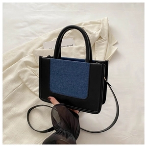 Detail der modischen Canvas-Leder-Handtasche mit stilvollen Nähten und quadratischer Form