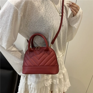 Elegant red quilted shell bag with golden hardware and adjustable leather shoulder strap