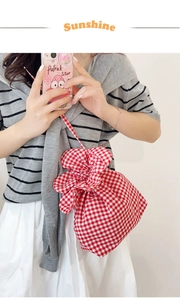 Detail of red gingham drawstring bucket bag with pleated ruffled edges and thin strap
