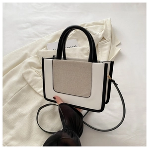 Detail der Canvas-Kontrasttasche mit Ledergriffen und langem Schultergurt