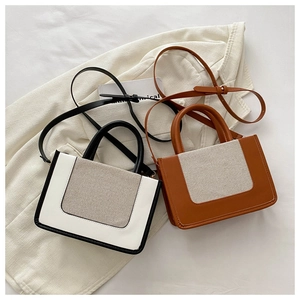 Detail von stylischen Canvas- und Kunstleder-Handtaschen in Weiß und Braun