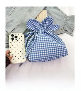 Mini gingham drawstring bucket bag with blue and white pattern and ruffled edge detail